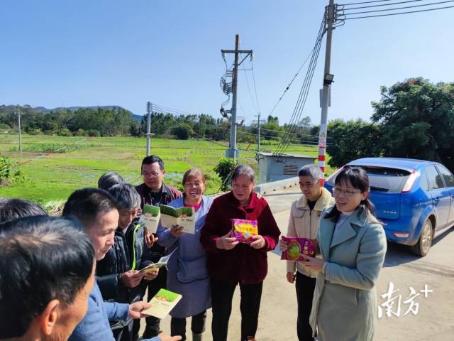 向農戶派發水稻“三控”施肥技術手冊。